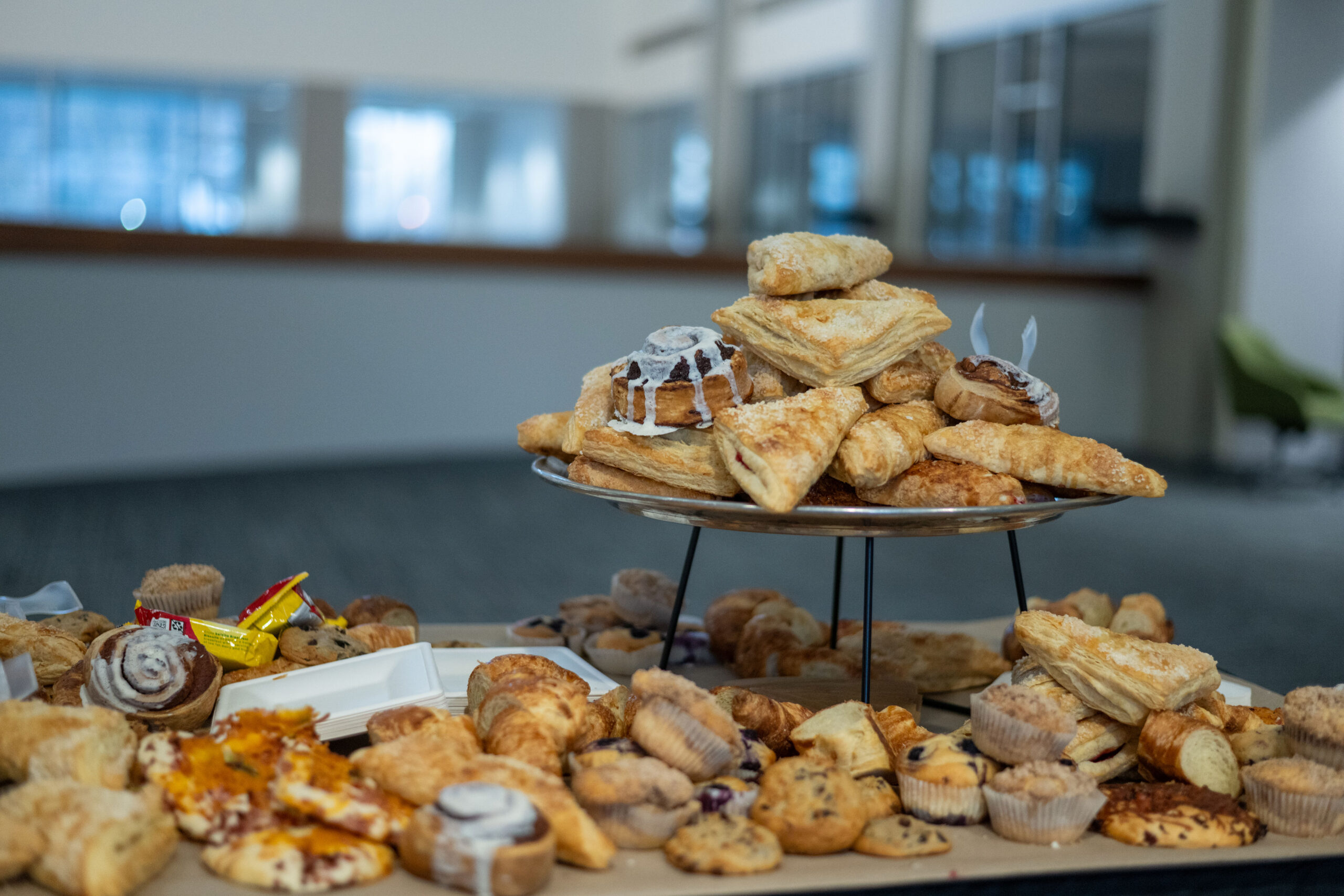 A display of assorted pastries on a tiered stand and trays.