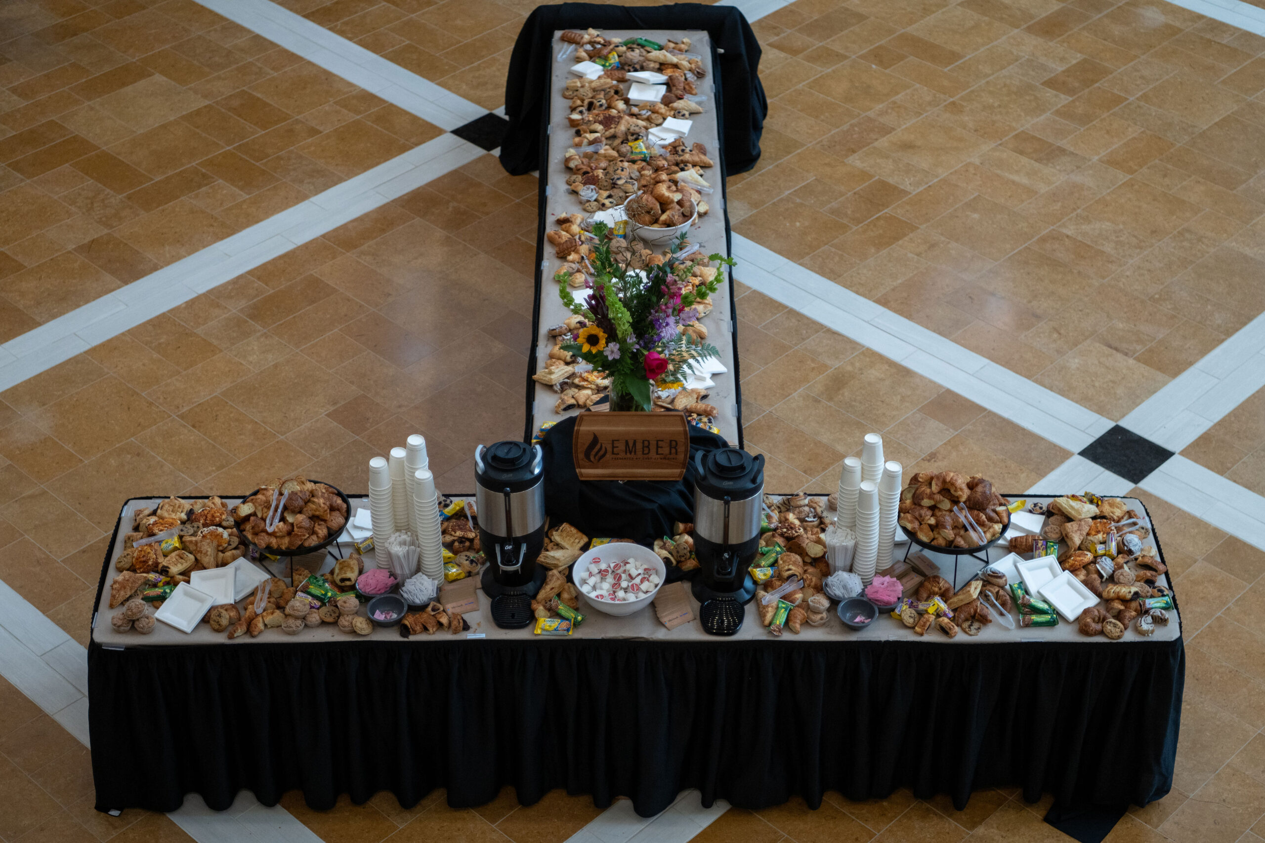 Elegant dessert table with a variety of sweets and floral centerpiece.
