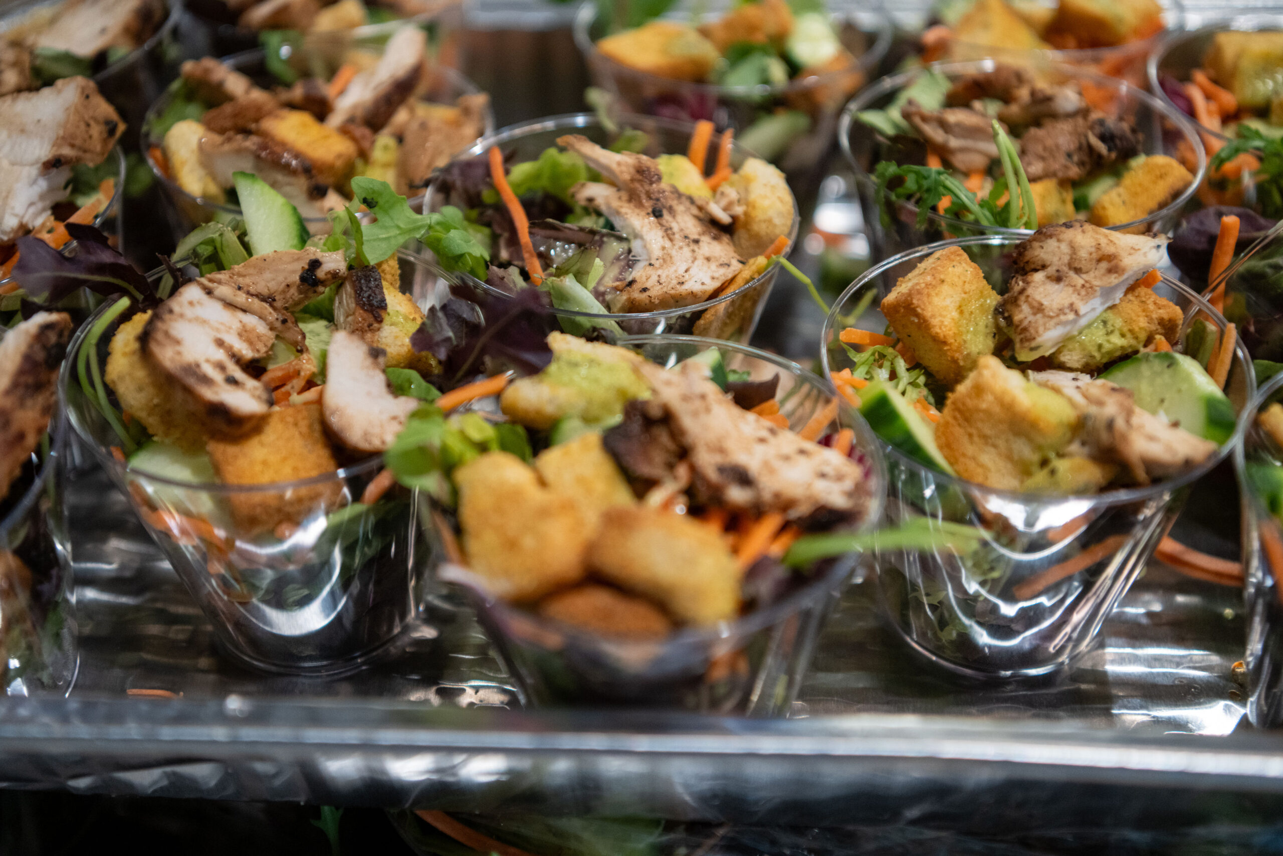 Elegant appetizers with shrimp and greens in glass cups.