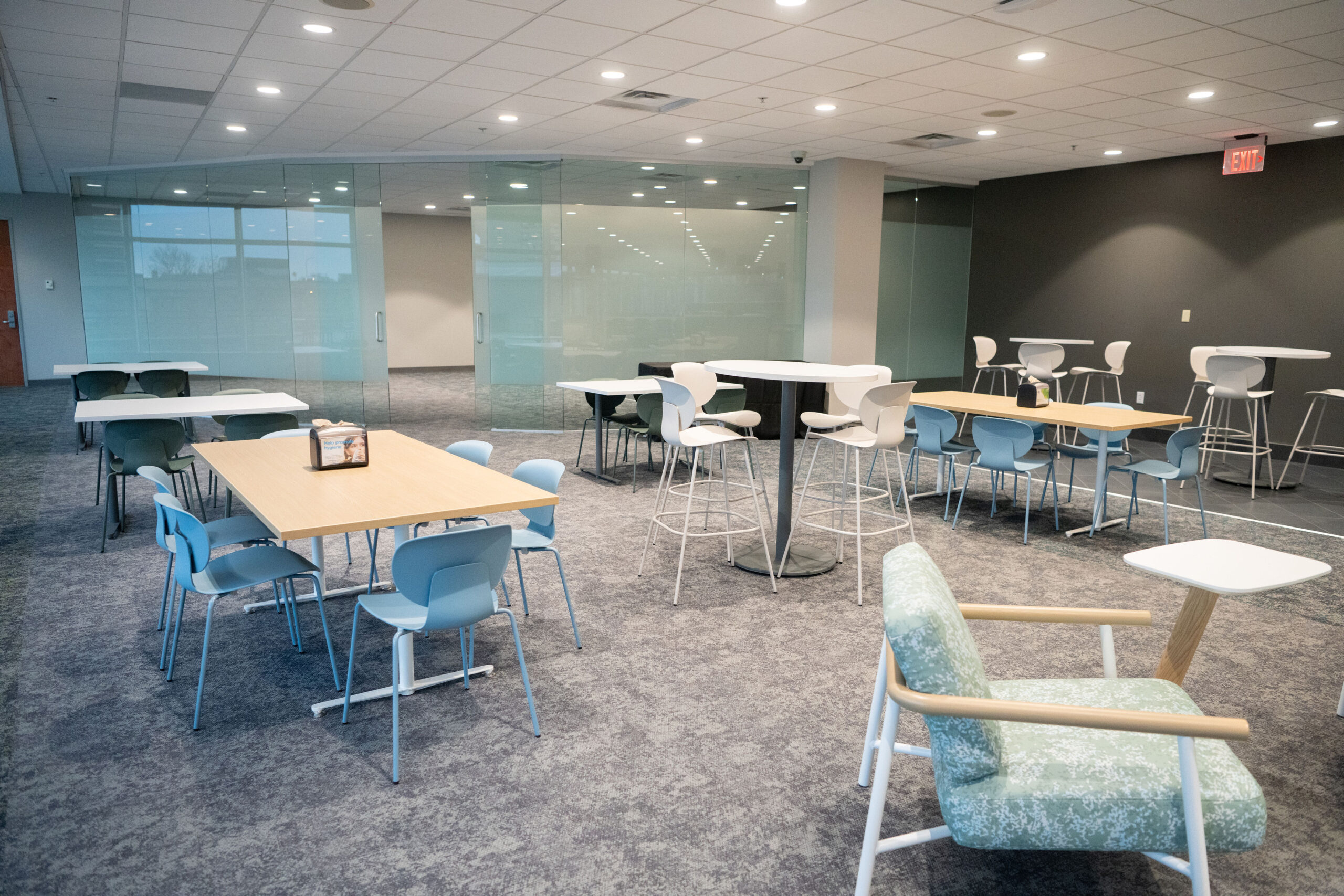Modern office break room with tables and chairs.